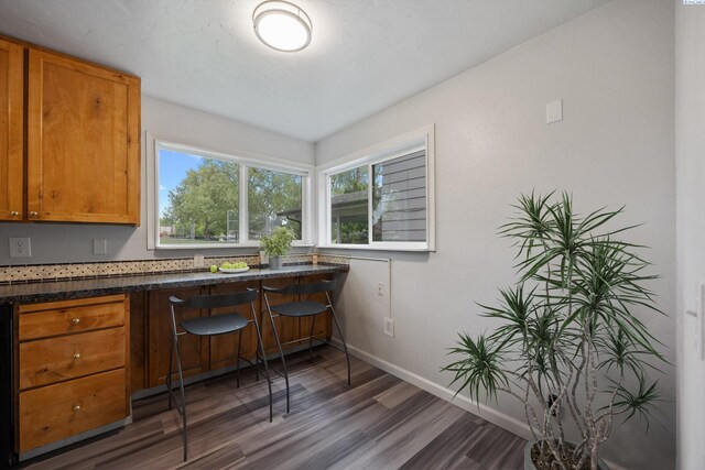 312 Mccabe St, Walla Walla, WA 99362 - kitchen featuring wood finished floors, baseboards, brown cabinets, and dark countertops