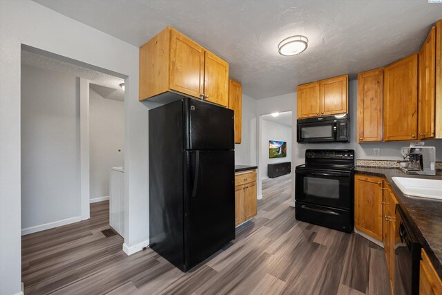 312 Mccabe St, Walla Walla, WA 99362 - kitchen with black appliances, dark wood finished floors, dark countertops, and a sink