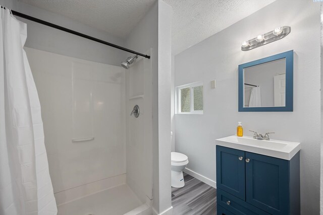 312 Mccabe St, Walla Walla, WA 99362 - bathroom with toilet, a textured ceiling, wood finished floors, a shower with shower curtain, and vanity