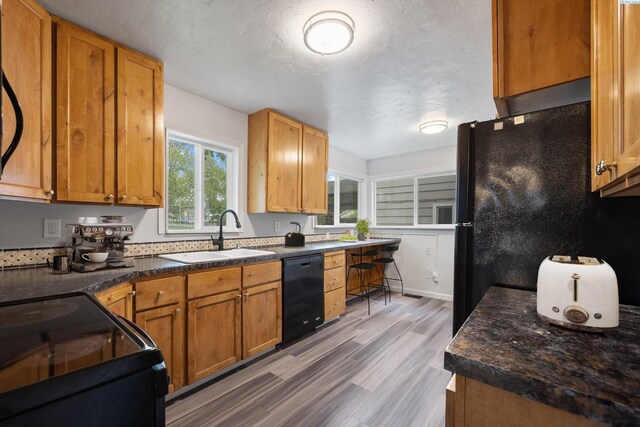 312 Mccabe St, Walla Walla, WA 99362 - kitchen with a sink, black appliances, wood finished floors, and dark countertops