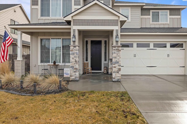 view of front of house with driveway, stone siding, an attached garage, a front lawn, and board and batten siding