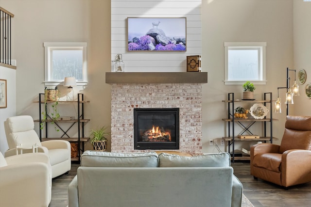 living room with dark wood-style floors and a brick fireplace