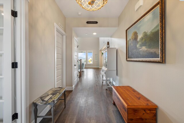 hallway featuring dark wood-style flooring and baseboards