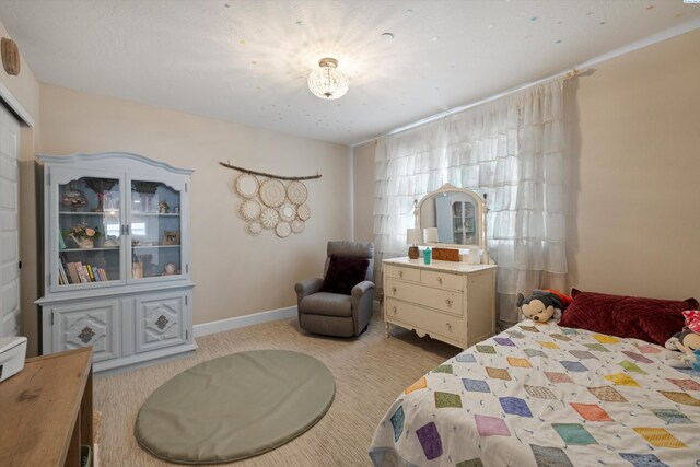 bedroom with baseboards and light colored carpet