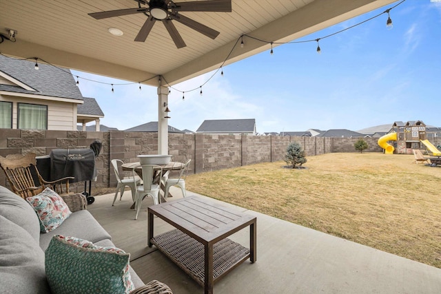 view of patio / terrace with outdoor dining area, a playground, outdoor lounge area, ceiling fan, and a fenced backyard