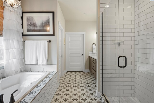 bathroom featuring a garden tub, a shower stall, baseboards, and vanity