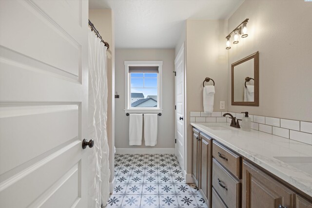 bathroom featuring tile patterned floors, a sink, baseboards, and double vanity