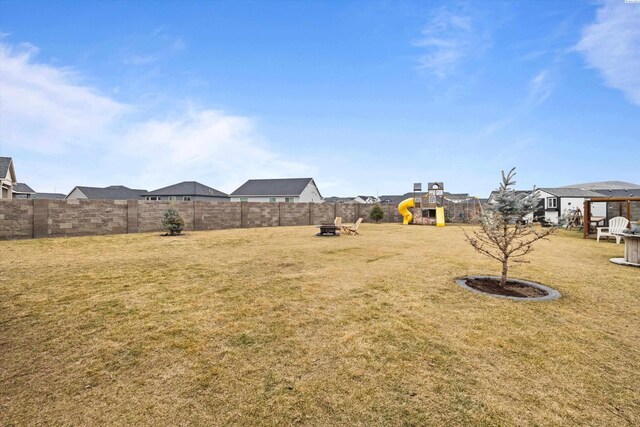 view of yard featuring a fenced backyard, a residential view, and a playground