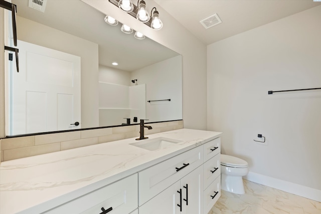 bathroom with vanity, toilet, and a shower