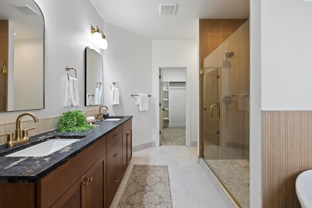 bathroom with a shower with door, vanity, and tile patterned floors