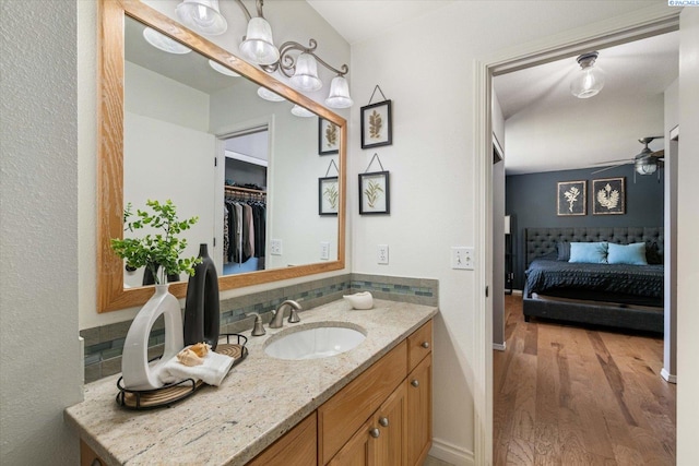 2330 Hummingbird Ln, West Richland, WA 99353 - bathroom featuring wood finished floors, ceiling fan, vanity, backsplash, and a spacious closet