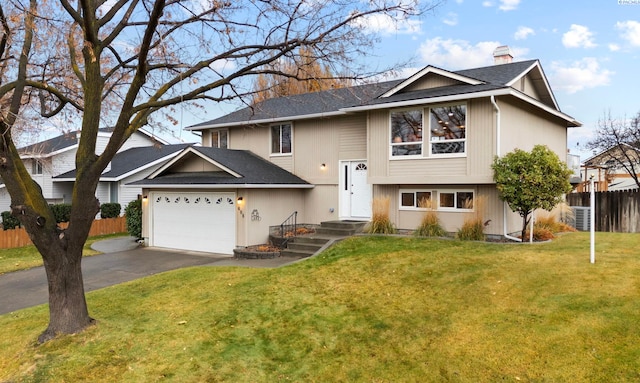 split foyer home featuring a garage and a front yard