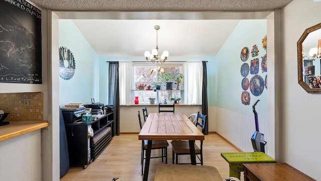 2113 Rainier Ave, Richland, WA 99354 - dining room with a textured ceiling, an inviting chandelier, wainscoting, and light wood finished floors
