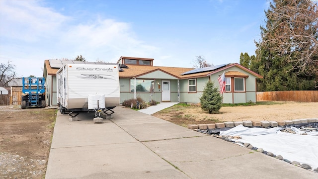 2113 Rainier Ave, Richland, WA 99354 - view of front facade featuring roof mounted solar panels, concrete driveway, and fence