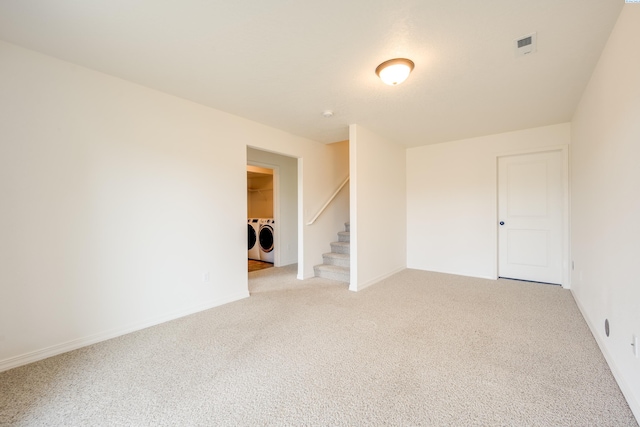 empty room with light colored carpet and independent washer and dryer