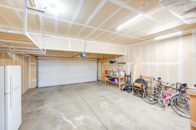 garage with a garage door opener and white fridge