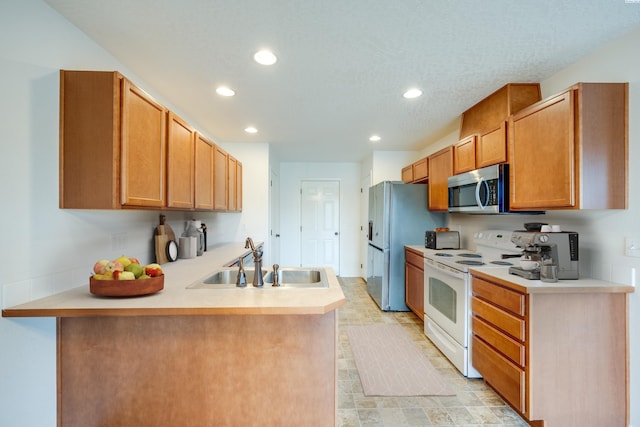 kitchen with appliances with stainless steel finishes, sink, and kitchen peninsula