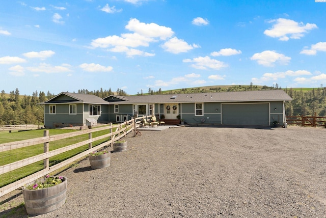 view of front facade featuring an attached garage, driveway, fence, and french doors