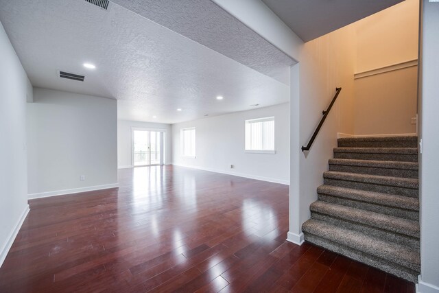 1390 SW Panorama Dr, Pullman, WA 99163 - unfurnished living room with baseboards, stairway, a textured ceiling, dark wood-style flooring, and recessed lighting
