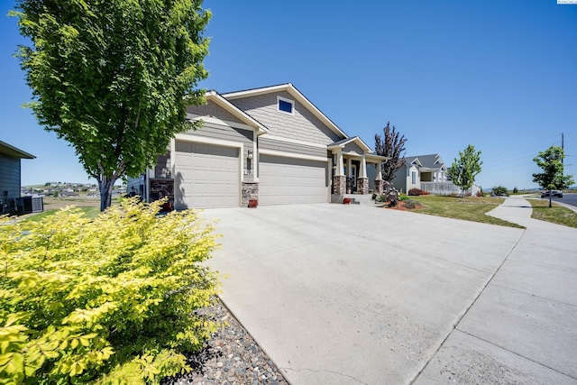 1390 SW Panorama Dr, Pullman, WA 99163 - craftsman inspired home featuring an attached garage, concrete driveway, stone siding, and central AC