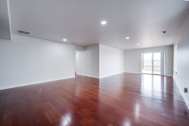 1390 SW Panorama Dr, Pullman, WA 99163 - empty room featuring a textured ceiling, dark wood-type flooring, recessed lighting, and baseboards