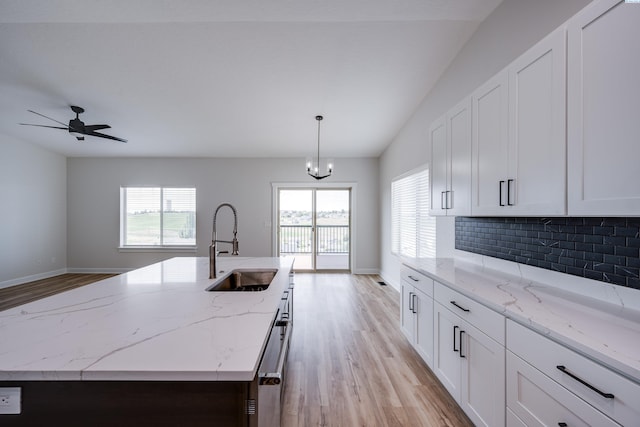 1390 SW Panorama Dr, Pullman, WA 99163 - kitchen with a sink, light wood-style flooring, healthy amount of natural light, backsplash, and lofted ceiling