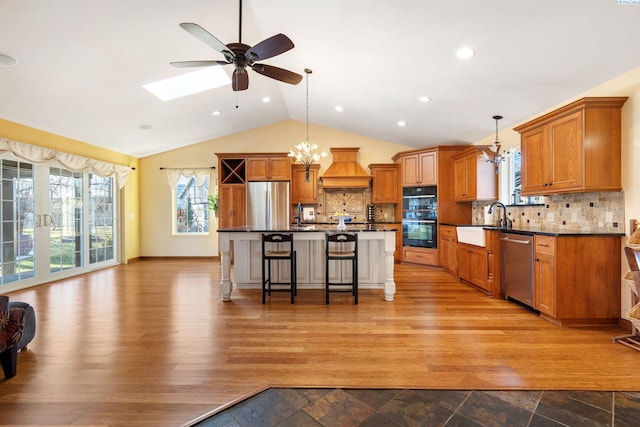 1515 Hains Ave, Richland, WA 99354 - kitchen featuring stainless steel appliances, premium range hood, a sink, a kitchen breakfast bar, and dark countertops