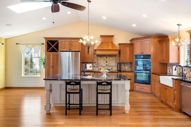 1515 Hains Ave, Richland, WA 99354 - kitchen with brown cabinets, a kitchen breakfast bar, custom exhaust hood, stainless steel appliances, and a sink