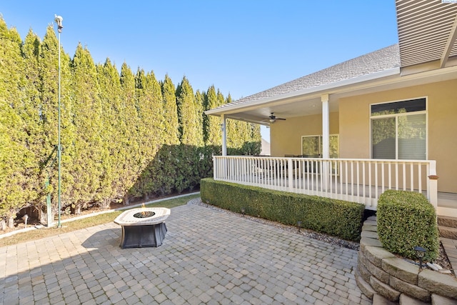 view of patio / terrace with a fire pit and a ceiling fan