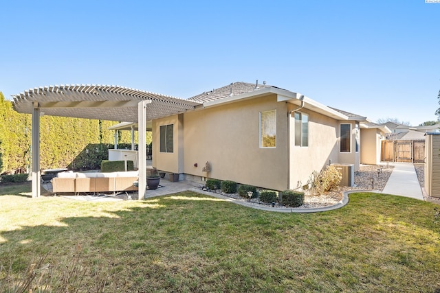 back of house featuring a lawn, a patio, fence, a pergola, and stucco siding