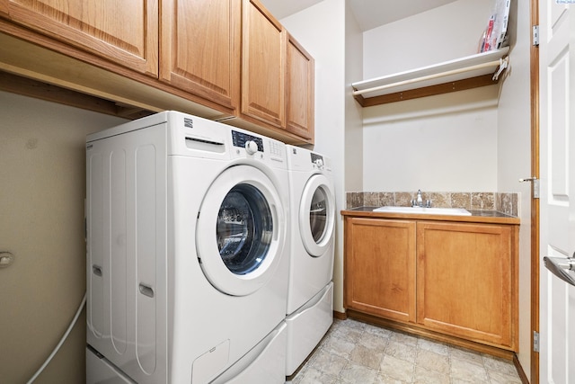 laundry area featuring washer and clothes dryer, a sink, and cabinet space