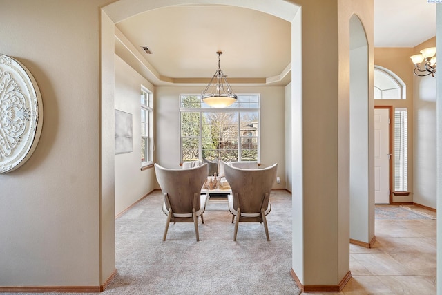 dining room featuring baseboards, visible vents, a raised ceiling, carpet floors, and a notable chandelier