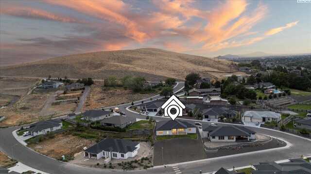 aerial view at dusk featuring a mountain view