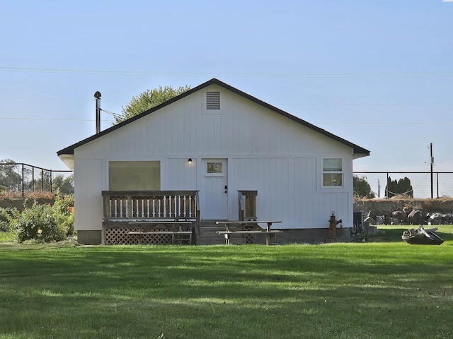 rear view of house with a wooden deck and a yard