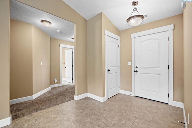 5709 W 23rd Ave, Kennewick, WA 99338 - foyer featuring a textured ceiling, light tile patterned floors, and light carpet