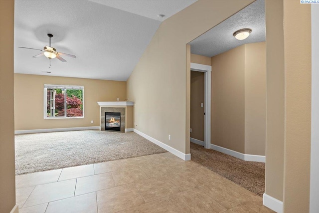 5709 W 23rd Ave, Kennewick, WA 99338 - unfurnished living room with light carpet, ceiling fan, a glass covered fireplace, light tile patterned flooring, and a textured ceiling