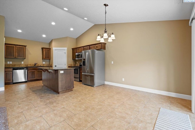 5709 W 23rd Ave, Kennewick, WA 99338 - kitchen featuring stainless steel appliances, a chandelier, a kitchen island, a breakfast bar area, and decorative light fixtures