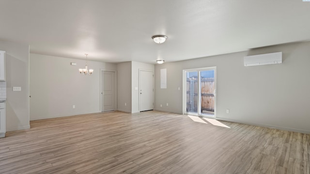 414 Whitefish Ln, Pasco, WA 99301 - unfurnished room with a wall unit AC, a chandelier, light wood-type flooring, and baseboards