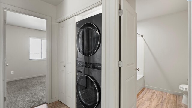 414 Whitefish Ln, Pasco, WA 99301 - clothes washing area with stacked washer and clothes dryer, baseboards, and light wood-style flooring