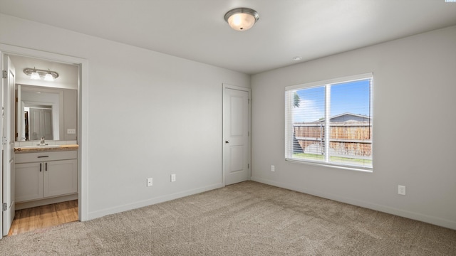 414 Whitefish Ln, Pasco, WA 99301 - unfurnished bedroom featuring light carpet, a sink, baseboards, and connected bathroom