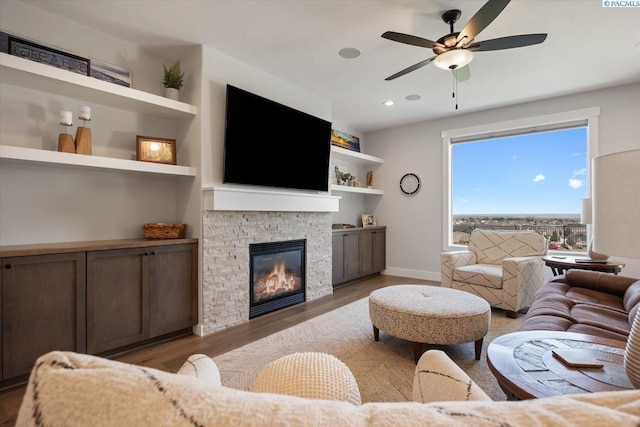 5770 W 40th Ave, Kennewick, WA 99338 - living room featuring wood finished floors, a stone fireplace, ceiling fan, built in features, and recessed lighting