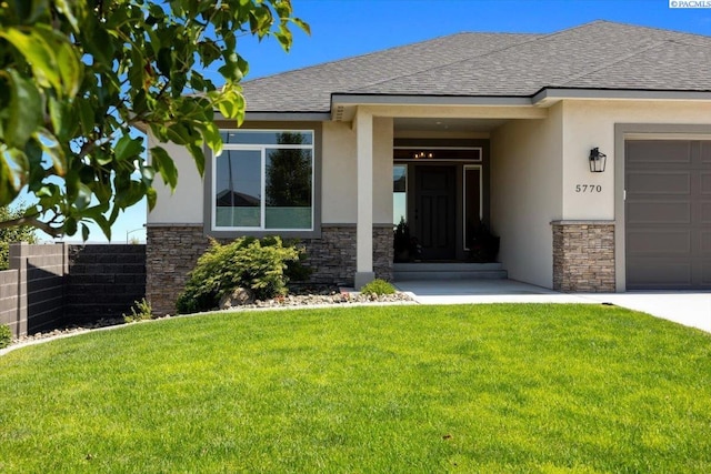 5770 W 40th Ave, Kennewick, WA 99338 - view of exterior entry featuring stone siding, stucco siding, a garage, and a shingled roof