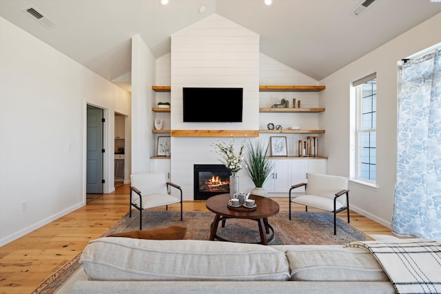 living room featuring high vaulted ceiling and light wood-type flooring