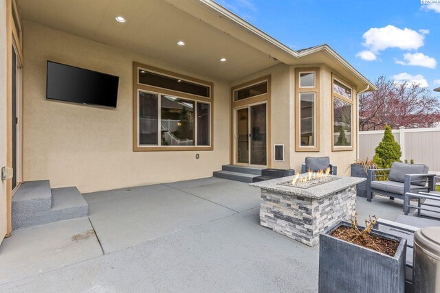 view of patio featuring a fire pit, entry steps, and fence