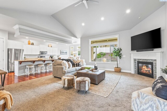 living area with carpet, baseboards, recessed lighting, a tiled fireplace, and a ceiling fan
