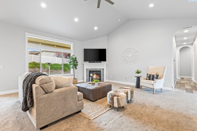 living room with vaulted ceiling, a ceiling fan, baseboards, light colored carpet, and arched walkways