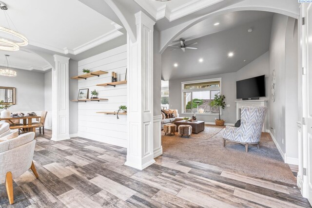 interior space with decorative columns, arched walkways, ceiling fan with notable chandelier, and crown molding