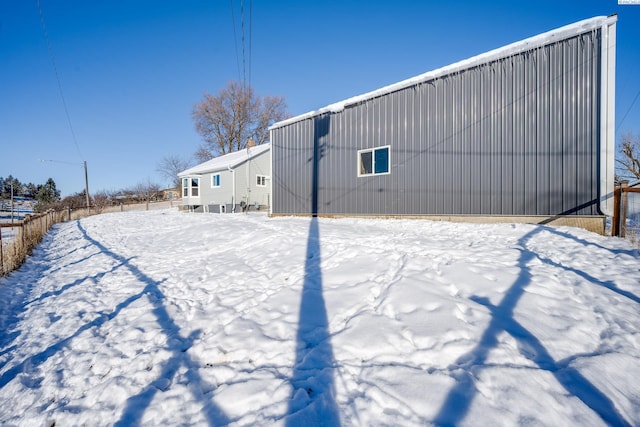 view of snow covered back of property