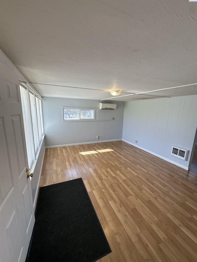 315 Robert Ave, Richland, WA 99352 - empty room featuring an AC wall unit, light wood finished floors, baseboards, and a decorative wall