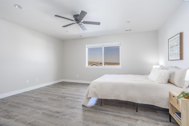 bedroom featuring a ceiling fan, visible vents, recessed lighting, wood finished floors, and baseboards